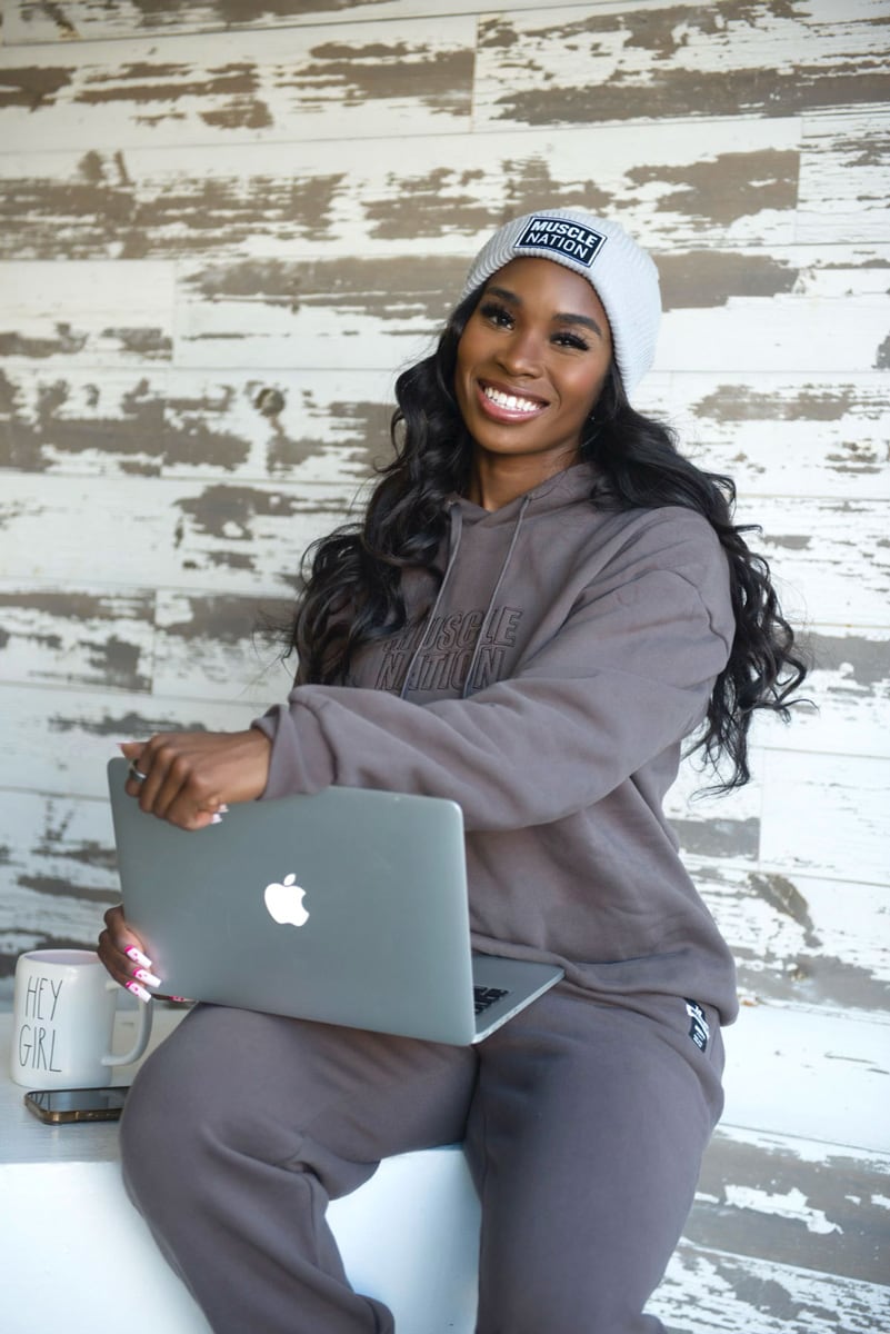 Coach Syd smiling and holding her laptop